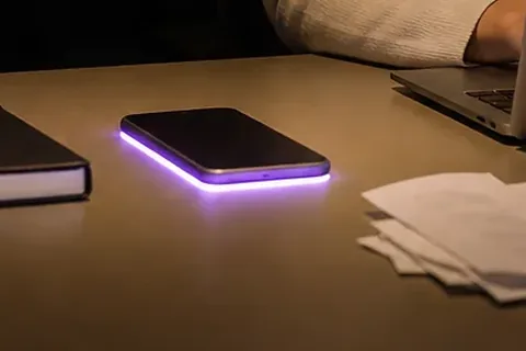 Phone glowing with a notification on a desk at night