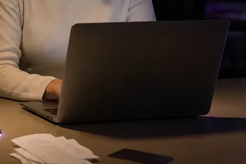 Laptop open on a finance desk at night