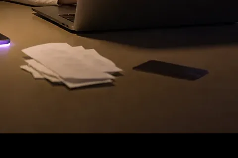 Corporate card and receipts on a desk under a spotlight